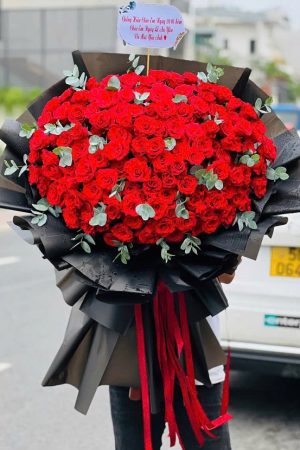 Bó hoa hồng đỏ gói giấy đen to sang trọng, nổi bật và đầy vẻ cuốn hút, mạnh mẽ.