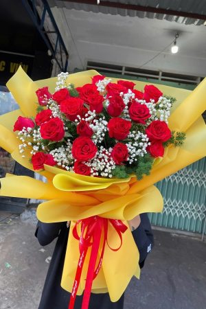 Bó hoa hồng đỏ gói giấy vàng nổi bật, sang trọng và đầy cảm xúc yêu thương.