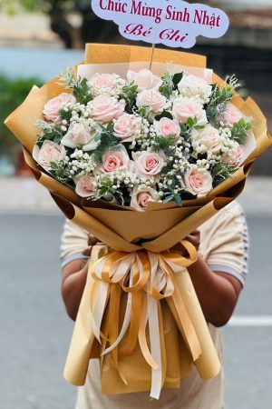 Bó hoa hồng kem gói giấy báo vintage, thanh lịch và tinh tế.