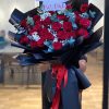 Bó hoa hồng đỏ gói giấy đen nổi bật, quyến rũ và sang trọng.