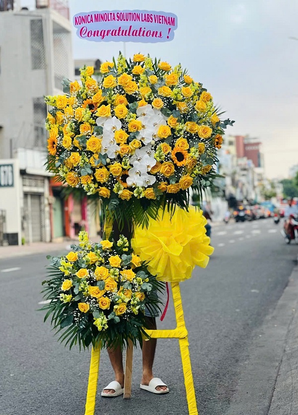 Kệ hoa khai trương rực rỡ, phối kết từ hoa đồng tiền, hồng vàng, lan vàng – mẫu được ưa chuộng tại tiệm hoa khai trương Việt Yên, giao nhanh trong 2 giờ.