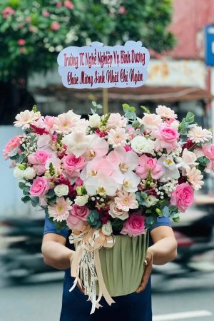 Một mẫu hoa nghệ thuật với sự kết hợp độc đáo giữa hoa hồng, lan hồ điệp và các phụ kiện tinh tế, tạo nên sự khác biệt tại shop hoa tươi Phú Giáo Bình Dương.
