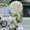 Kệ hoa viếng lan trắng phối cúc trắng 3 tầng hiện đại, trang nghiêm và tinh khôi, tượng trưng cho sự thành kính, tiếc thương và lời tiễn biệt trọn vẹn đến người đã khuất.
