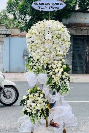 Kệ hoa viếng lan trắng phối cúc trắng 3 tầng hiện đại, trang nghiêm và tinh khôi, tượng trưng cho sự thành kính, tiếc thương và lời tiễn biệt trọn vẹn đến người đã khuất.