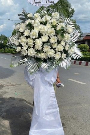 Kệ hoa viếng 1 tầng kết hợp hồng trắng và cúc trắng mang vẻ đẹp thuần khiết, trang nghiêm. Hồng trắng tượng trưng cho sự tôn kính, yêu thương tinh khôi, còn cúc trắng thể hiện niềm tiếc thương và lòng thành kính, là lời tiễn biệt trang trọng gửi đến người đã khuất.