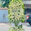 Kệ hoa viếng lan trắng phối cúc 2 tầng đẹp, trang nhã và thanh khiết, thể hiện sự kính trọng và niềm tiếc thương sâu sắc dành cho người đã khuất.