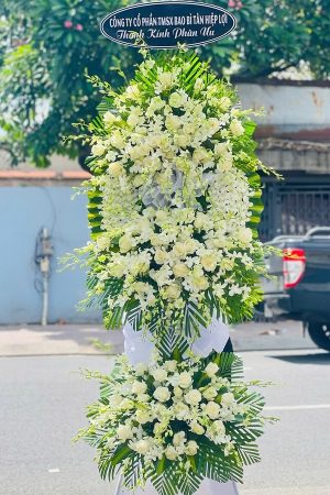 Kệ hoa viếng lan trắng phối cúc 2 tầng đẹp, trang nhã và thanh khiết, thể hiện sự kính trọng và niềm tiếc thương sâu sắc dành cho người đã khuất.