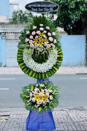Kệ hoa viếng 2 tầng kết hợp lan trắng, hồng kem và ly vàng, mang vẻ trang nhã, thanh khiết và sang trọng, thể hiện lòng thành kính.
