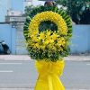 Kệ hoa viếng 1 tầng với lan vàng và ly vàng mang sắc vàng trang nghiêm, tượng trưng cho sự cao quý và lòng kính trọng. Sự kết hợp hài hòa này thể hiện niềm tiếc thương sâu sắc, đồng thời gửi lời chia buồn trang trọng đến gia đình người đã khuất.