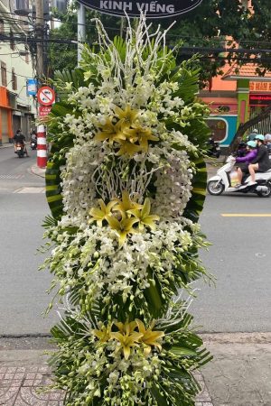 Lẵng hoa viếng màu trắng 3 tầng trang trọng, thanh khiết, bày tỏ sự kính trọng và niềm tiếc thương sâu sắc dành cho người đã khuất.