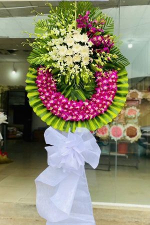 Vòng hoa chia buồn tone trắng tím trang nhã, được thiết kế thủ công tại shop hoa tươi Bình Đại – giao nhanh nhà tang lễ trong khu vực.