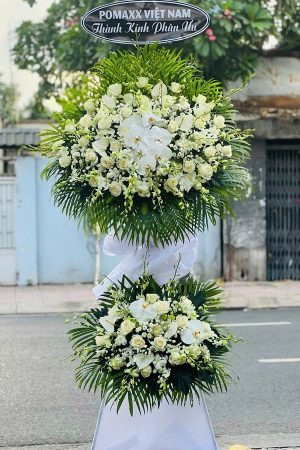 Kệ hoa viếng 2 tầng màu trắng trang nhã, kết hợp lan trắng, hồng trắng và hồ điệp, mang vẻ thanh khiết và trang trọng, thể hiện lòng thành kính.