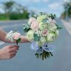 Bó hoa cưới rực rỡ và tinh tế, gồm những bông hoa tươi chọn lọc kỹ càng, thường là hoa hồng, baby, hoặc lan trắng, kết hợp hài hòa với lá xanh và phụ kiện nhẹ nhàng. Bó hoa được cắm khéo léo, vừa vặn, mang nét duyên dáng, lãng mạn, là điểm nhấn hoàn hảo cho ngày trọng đại của cô dâu.