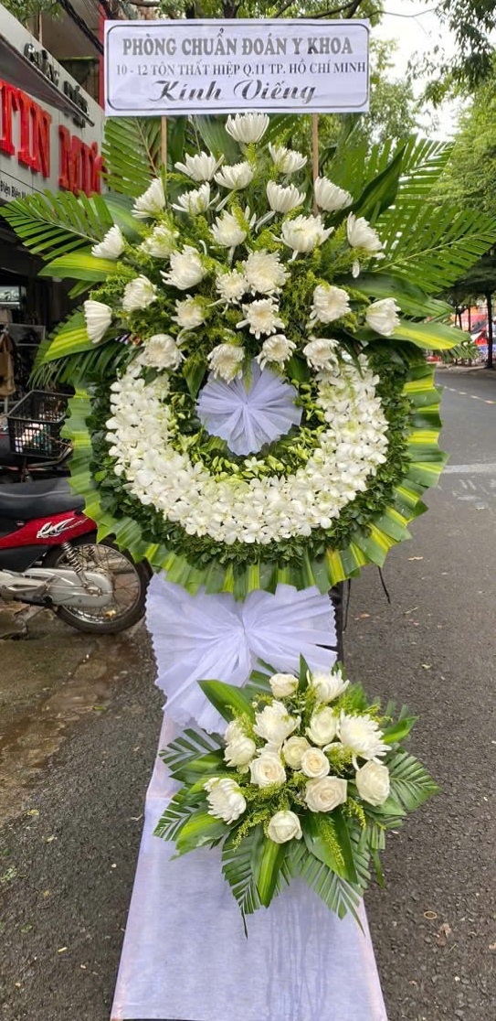 Kệ hoa viếng 2 tầng hiện đại Quảng Bình – Kết hợp hoa cúc trắng, lan tím, lan trắng, dịch vụ đặt hoa tận nơi nhanh chóng.